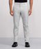 A person wears light gray Jack Archer Jetsetter Tech Pant, a black shirt, and black shoes, standing facing forward against a plain gray background.