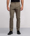 Wearing Jack Archer's wrinkle-resistant olive green Jetsetter Tech Pant, a person—upper body not visible—stands in black shirt and sneakers against a plain light grey background.