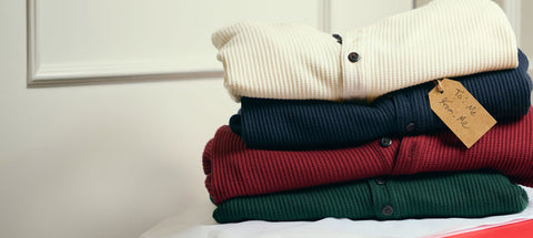 Waffle-knit henleys in cream, navy, red and green stacked with a tag reading To: Me, From: Me.
