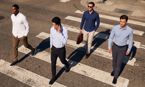 Four men in button-up shirts and dress pants crossing a city street on a crosswalk, seen from above