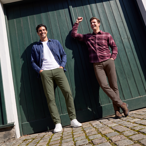 Two men in Charter Twill Pants, Olive and Deep Taupe, with navy and burgundy shirts against a green wooden door