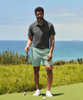 Man wearing Jetsetter Tech Short on a golf course with ocean view.