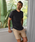 Man wearing Jetsetter Tech Short in a casual indoor setting.