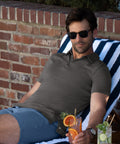 Man wearing a Jetsetter Tech Polo sitting outdoors with a drink.