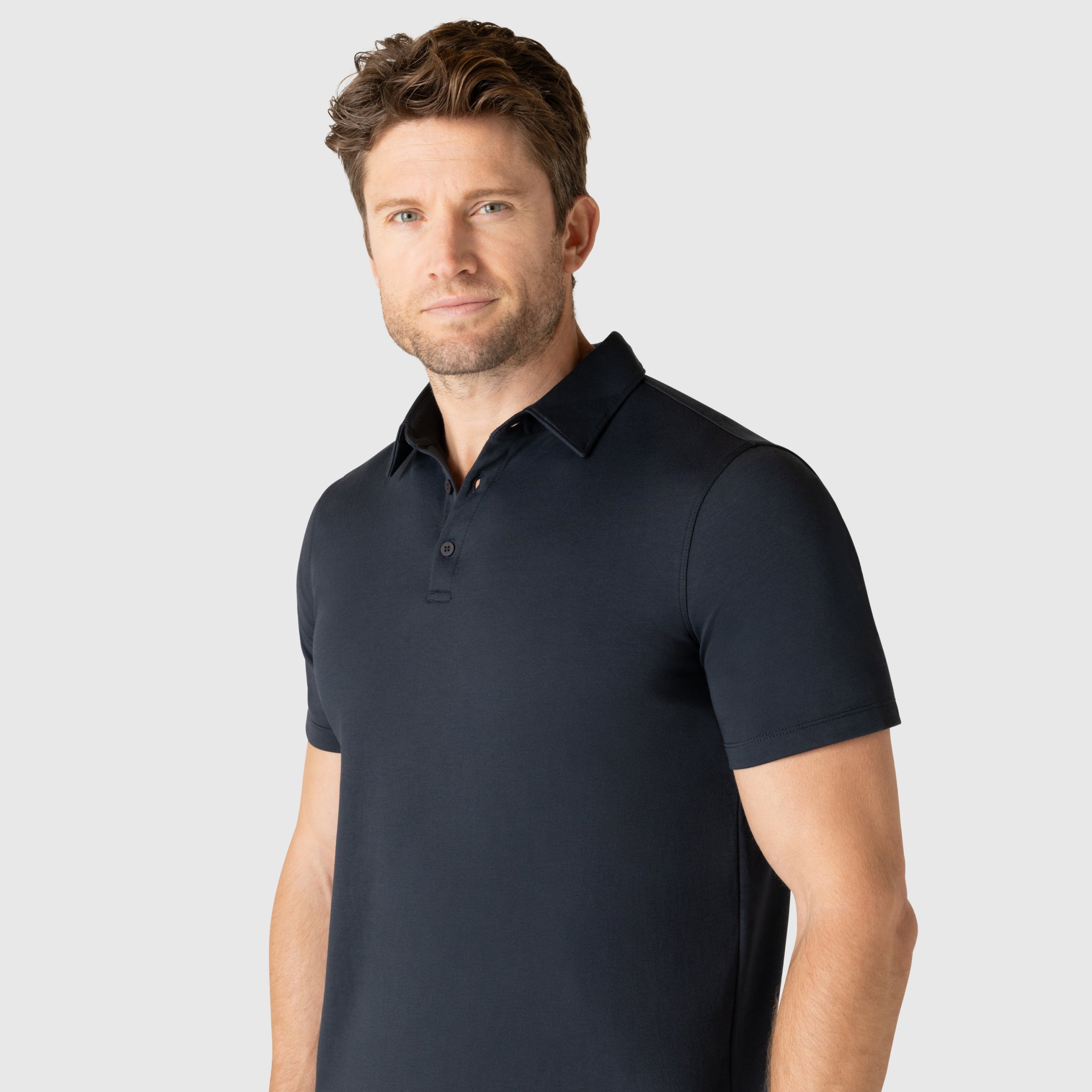 Modern man wearing Jetsetter Tech Polo with structured collar and tailored fit.