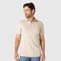 Man wearing Golf Game Essentials deep blue polo and sand stone pants.