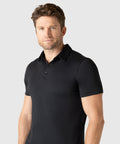 Man wearing a black Tech Polo with a tailored fit and structured collar.