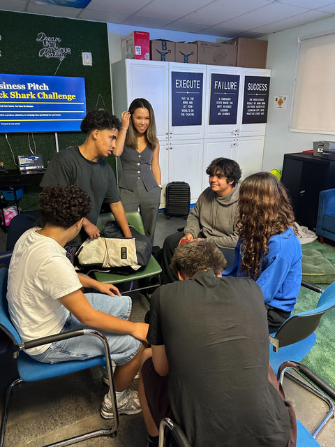 Jack Gives Back: students gathered around a table during a Business Pitch Shark Challenge classroom event