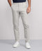 A person models the Jack Archer Jetsetter Tech Pant Straight Fit in Sand Stone, standing against a plain light gray background with hands in pockets and upper torso partially out of frame.