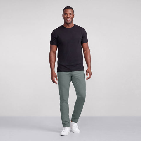 A man wearing the Jetsetter Tech Pant Slim Fit in Storm Green outdoors