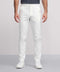 A person wearing white Jack Archer Jetsetter Tech Pant with white sneakers and a dark shirt stands against a light gray background, showing only the lower half of the body.