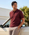 A man wearing the Legacy Resort Polo in Maroon, lifestyle setting.