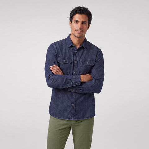 A man wearing the Chambray Shirt in Dark Wash