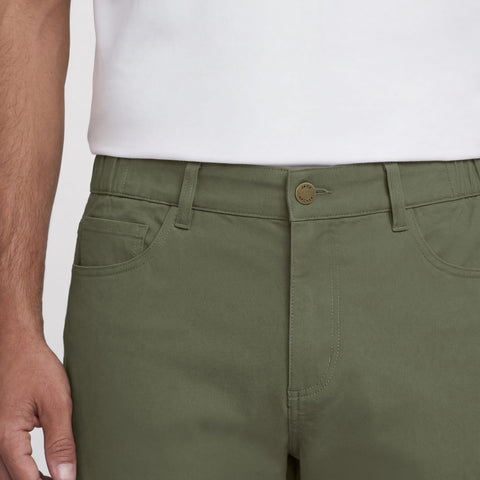 A man wearing the Charter Twill Pant in Olive outdoors