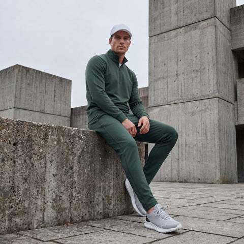 A man wearing the Clubhouse Range Jogger in Alpine Green in action