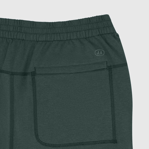 A man wearing the Clubhouse Range Jogger in Alpine Green outdoors