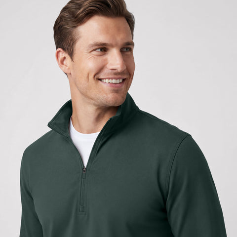 A man wearing the Clubhouse Range Quarter-Zip in Alpine Green outdoors