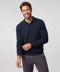 A navy knit long-sleeve polo worn with charcoal trousers.