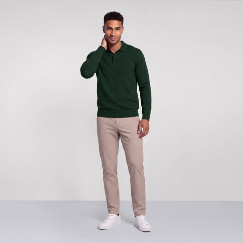 Full-length view of a dark pine green long-sleeve knit polo with stone chinos and white sneakers.
