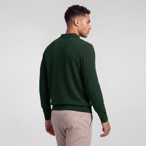 Back view of a dark pine green long-sleeve knit polo worn with stone chinos.
