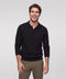 A black knit long-sleeve polo worn open at the collar with olive chinos.