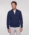 A man wearing a navy full-zip sweater over a white tee with stone chinos.