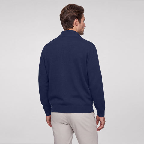 Back view of a navy full-zip sweater worn with stone chinos.