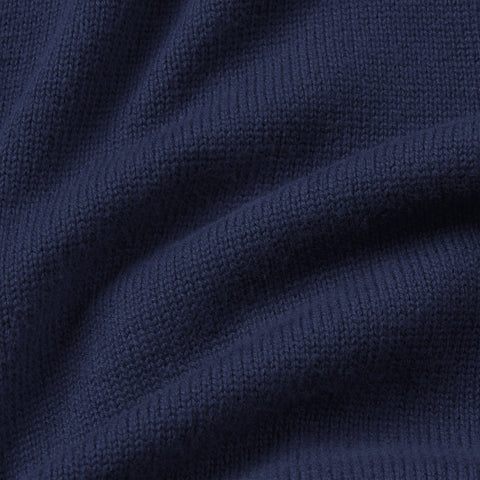 Close-up of the navy knit fabric of the full-zip sweater.