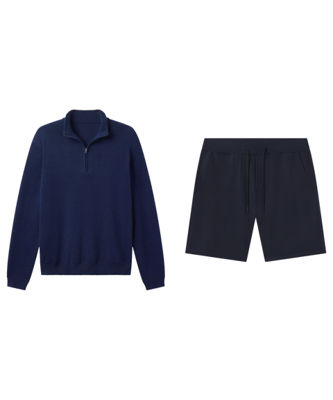 Navy quarter-zip sweater laid flat beside black drawstring knit shorts.