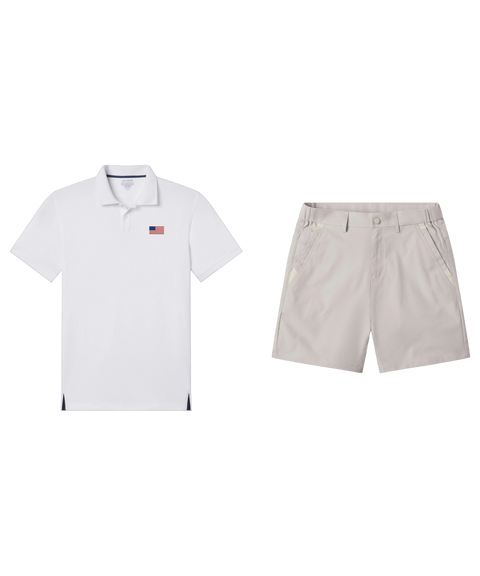 White polo with a U.S. flag chest patch paired with pale grey shorts, shown flat.