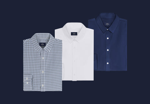 Three folded Everywear Shirts in Micro Check, True White and Navy on a dark navy background