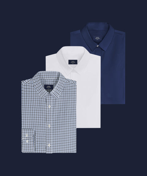 Three folded Everywear Shirts in Micro Check, True White and Navy on a dark navy background